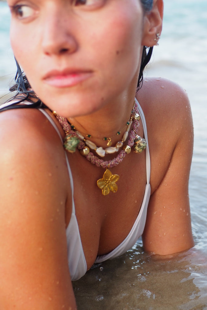 Woman with a necklace featuring a starfish pendant sitting in water
