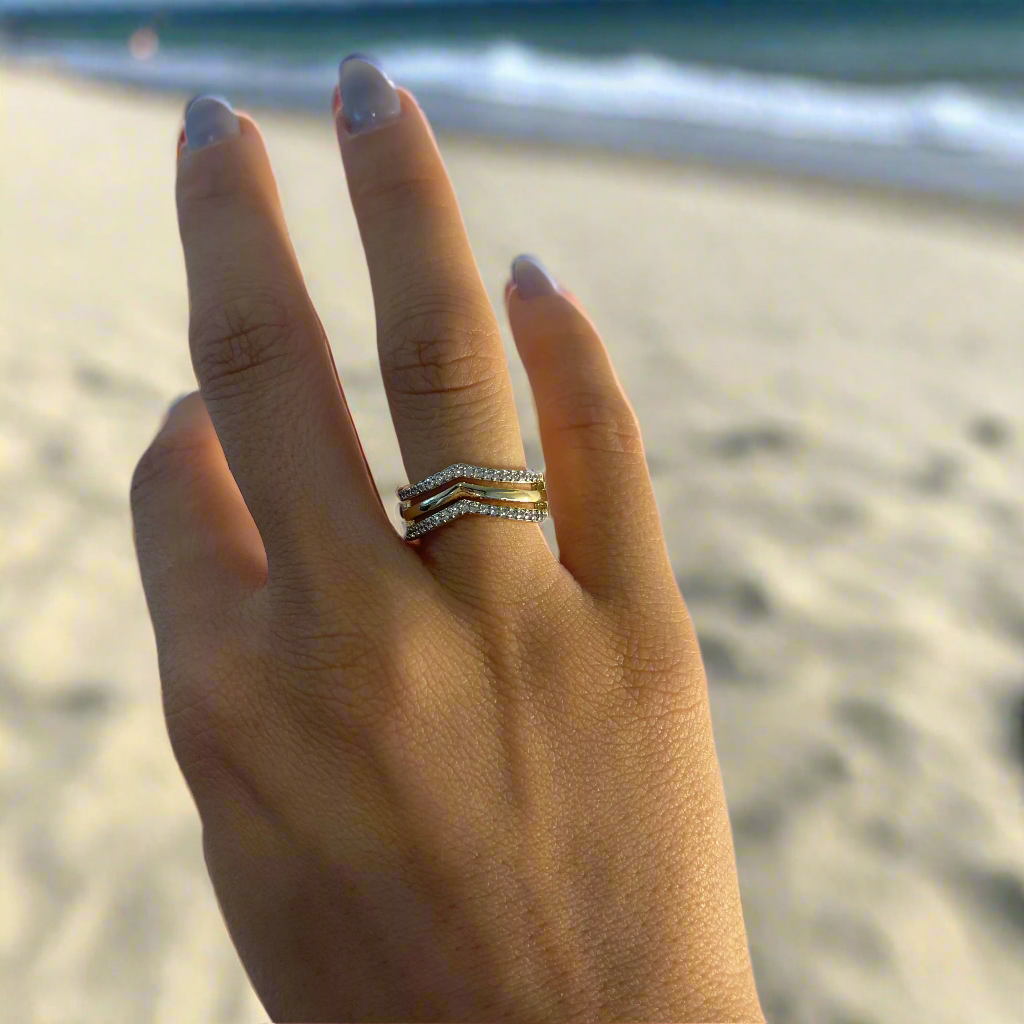 Hand wearing multiple rings on a white background