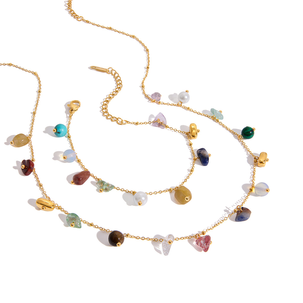 Gold necklace with multicolored gemstones on a white background