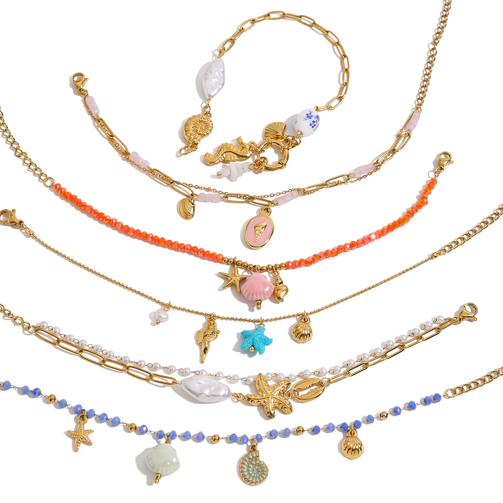 Set of layered necklaces with shell and starfish charms on a white background