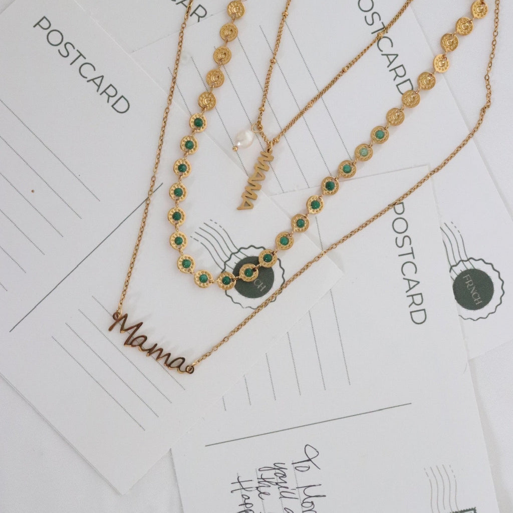 Gold necklaces with green beads on a postcard background