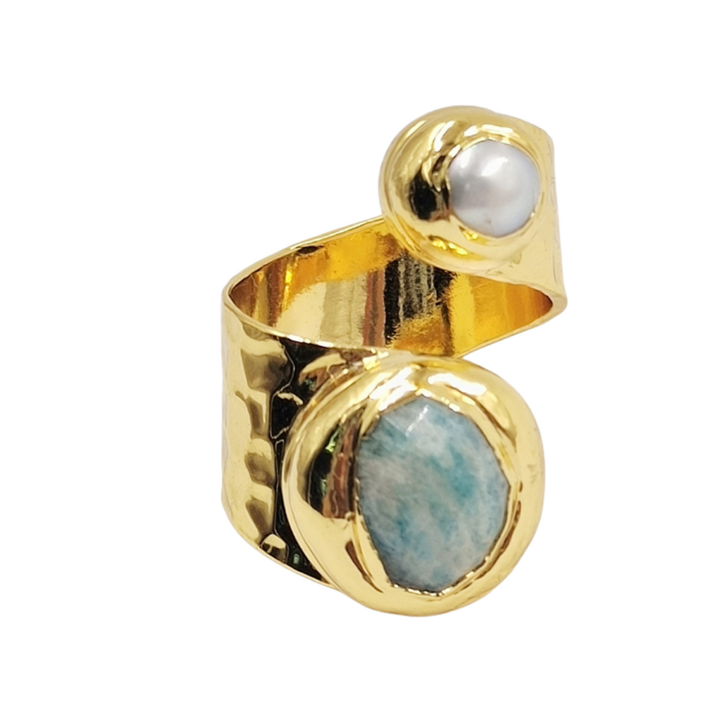 Gold ring with a pearl and gemstone on a white background